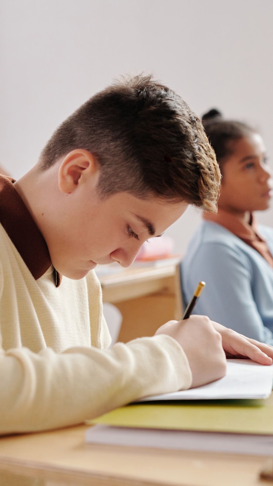 Illustrative image: students working in their notebooks.