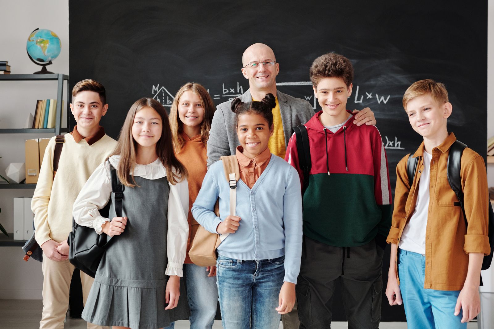 Illustrative image: students and their teacher in a classroom.